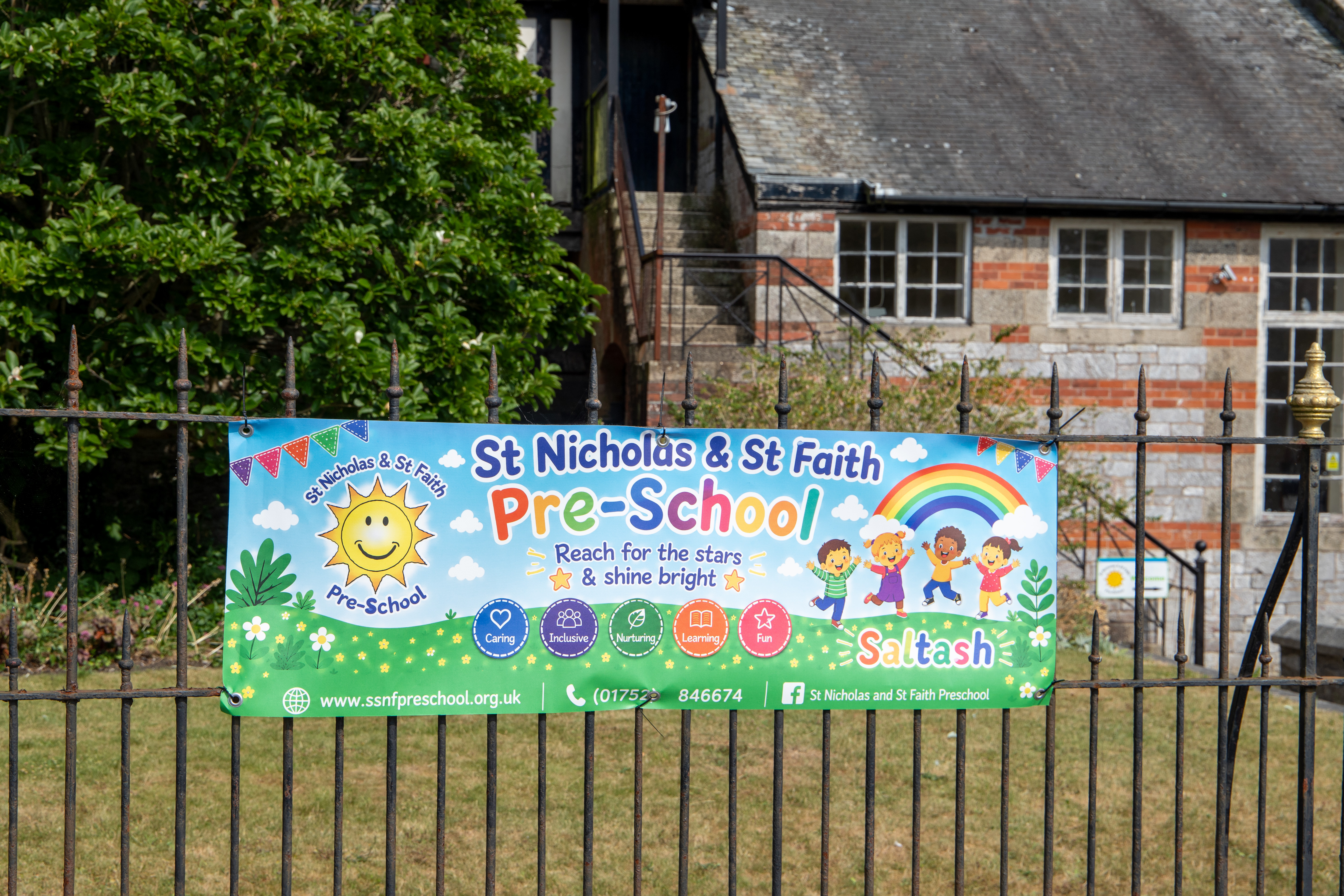 The St Nicholas & St Faith Pre-School banner on the railings outside the setting